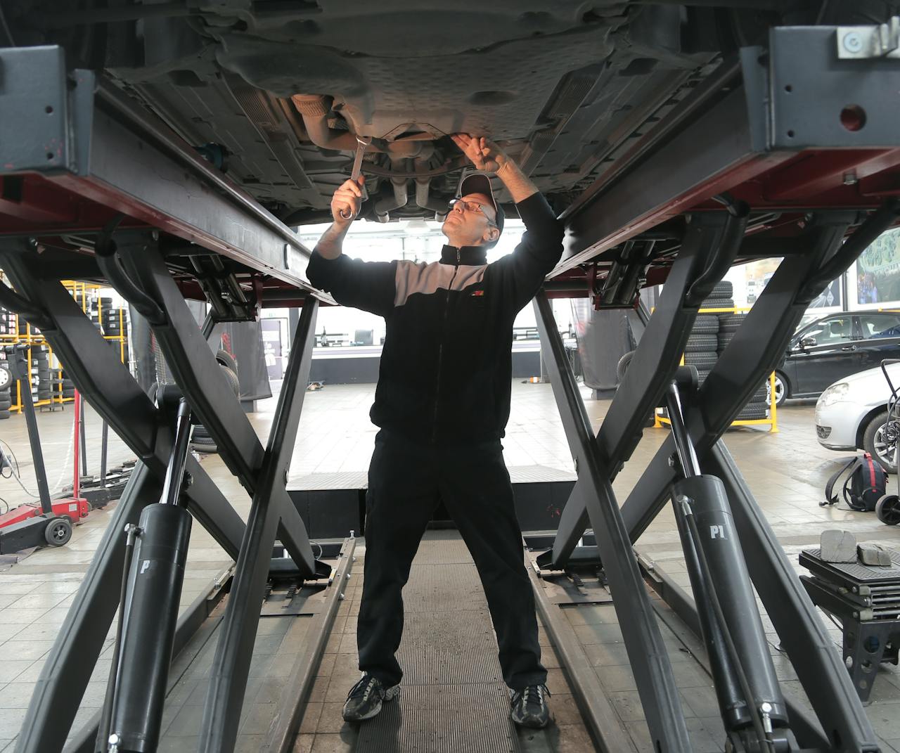 Home Mechanic inspecting and repairing a vehicle in a professional auto garage.